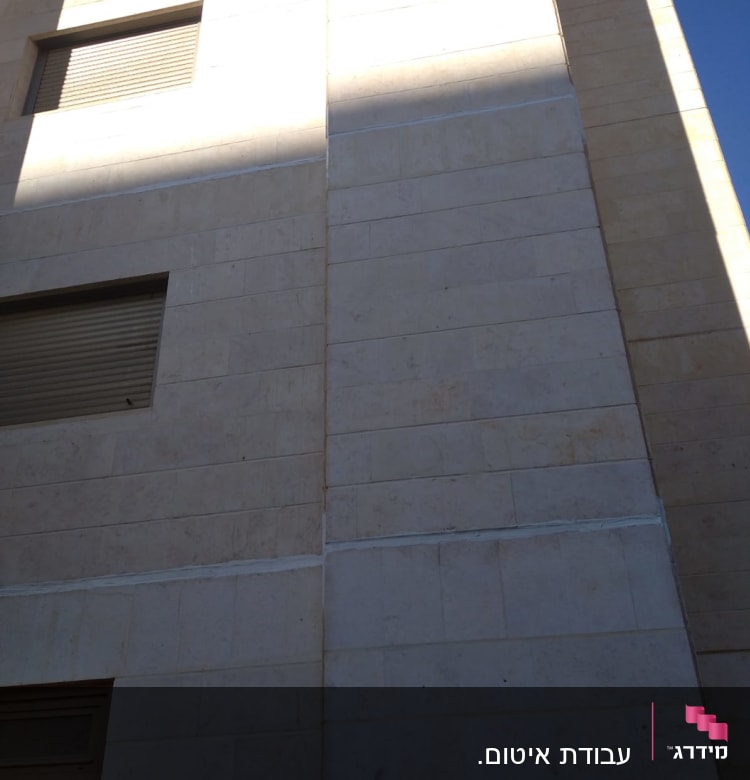 קיר בניין עם קווים אטומים בחומר איטום לבן